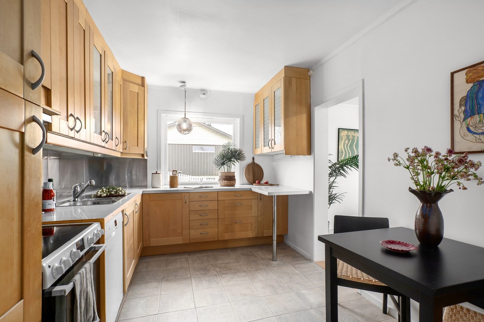 Romslig kjøkken med godt med skap- og benkeplass Galleribilde