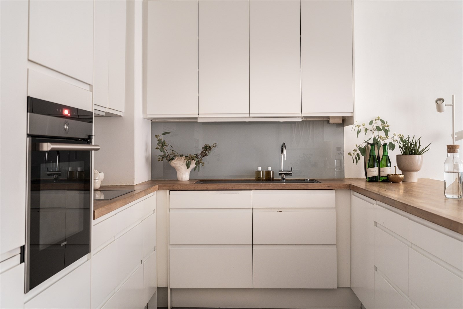 Kjøkkenet har glatte fronter, heltre benkeplate og integrerte hvitevarer som følger med. Galleribilde