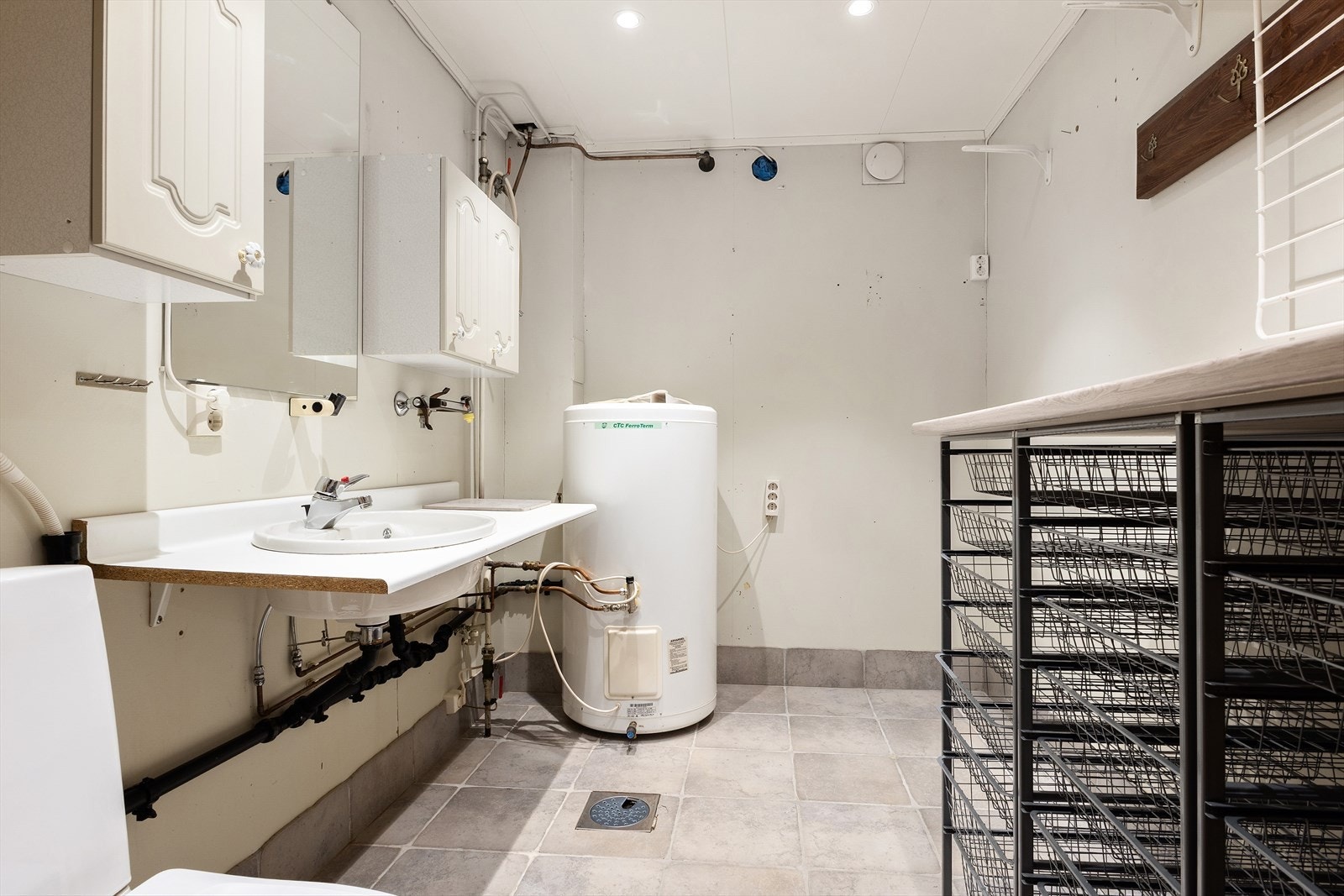 Vaskerom med gulvmontert toalett, enkel servantløsning. 200 liters v/v-bereder plassert i rommet. Galleribilde