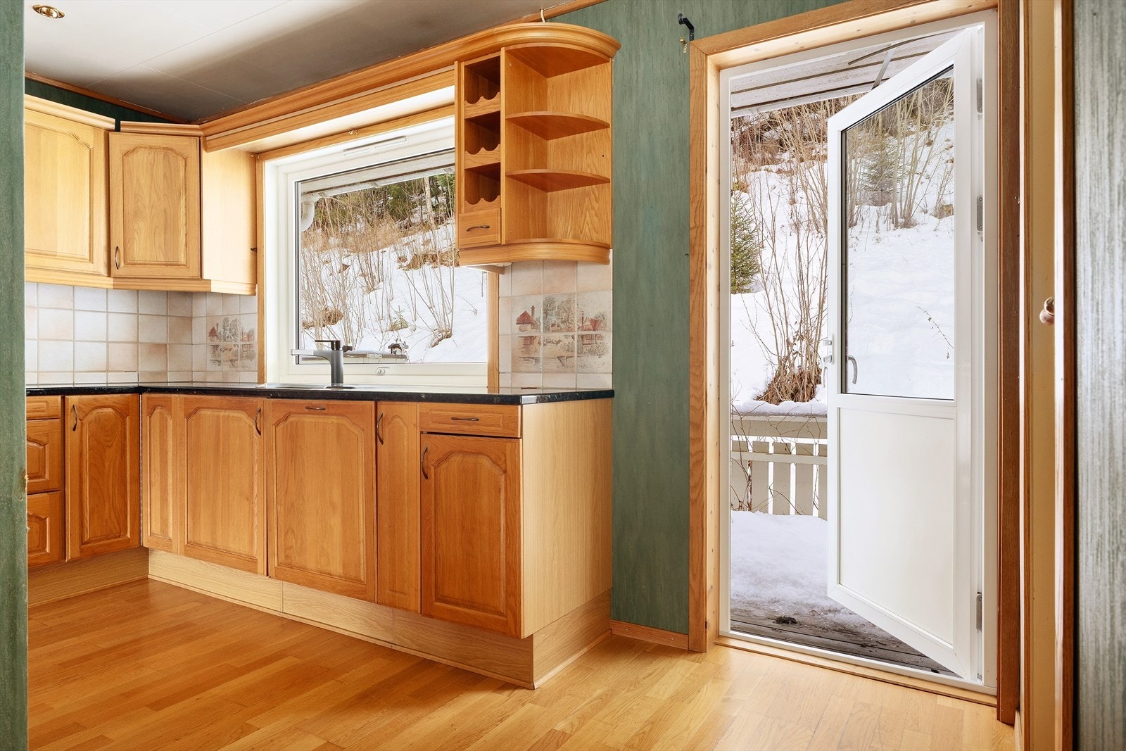 Ved kjøkkenet er det utgang til baksiden av huset og terrasse som er bygget langs siden av rekkehuset. Galleribilde