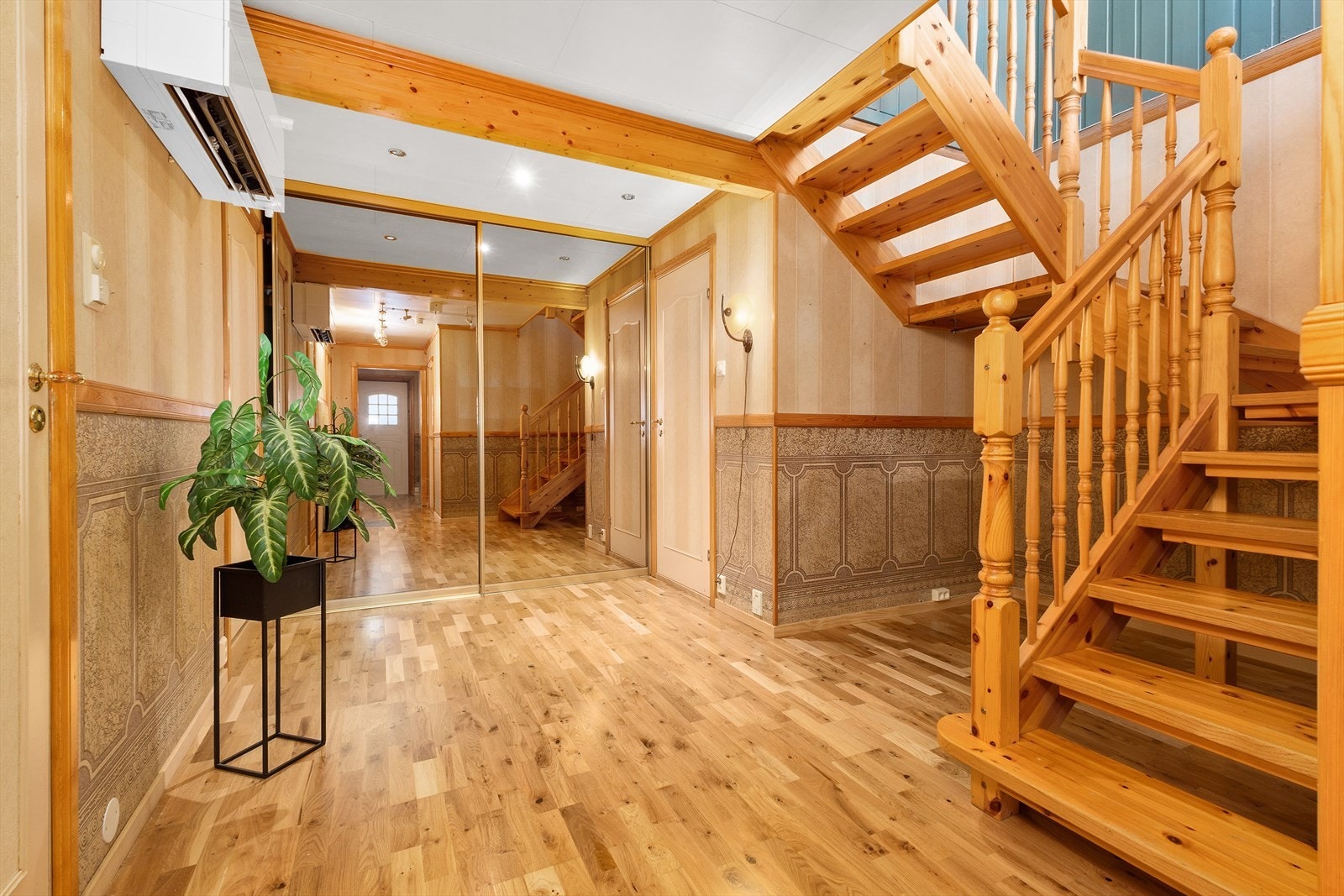 Romslig garderobe med speilfronter nederst i gangen. Varmepumpe montert ved trappen for god fordeling av varmluft mellom de to etasjene. Galleribilde