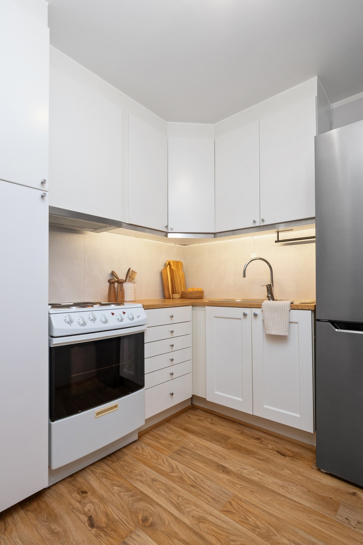 Innredningen har hvite fronter i glatt og profilert utførelse, kombinert med dobbel oppvaskkum og benkeplate av laminat. Galleribilde