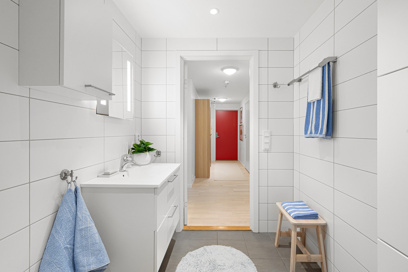 Av utstyr finnes servant på underskap, høyskap, speil, dusjnisje, veggmontert WC og opplegg for vaskemaskin. Galleribilde