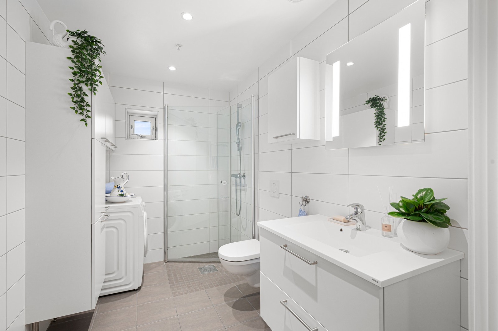 Lys flislagt bad på ca. 5,2m² med varmekabler i gulv. Rikelig med oppbevaringsplass i høyskap. Galleribilde