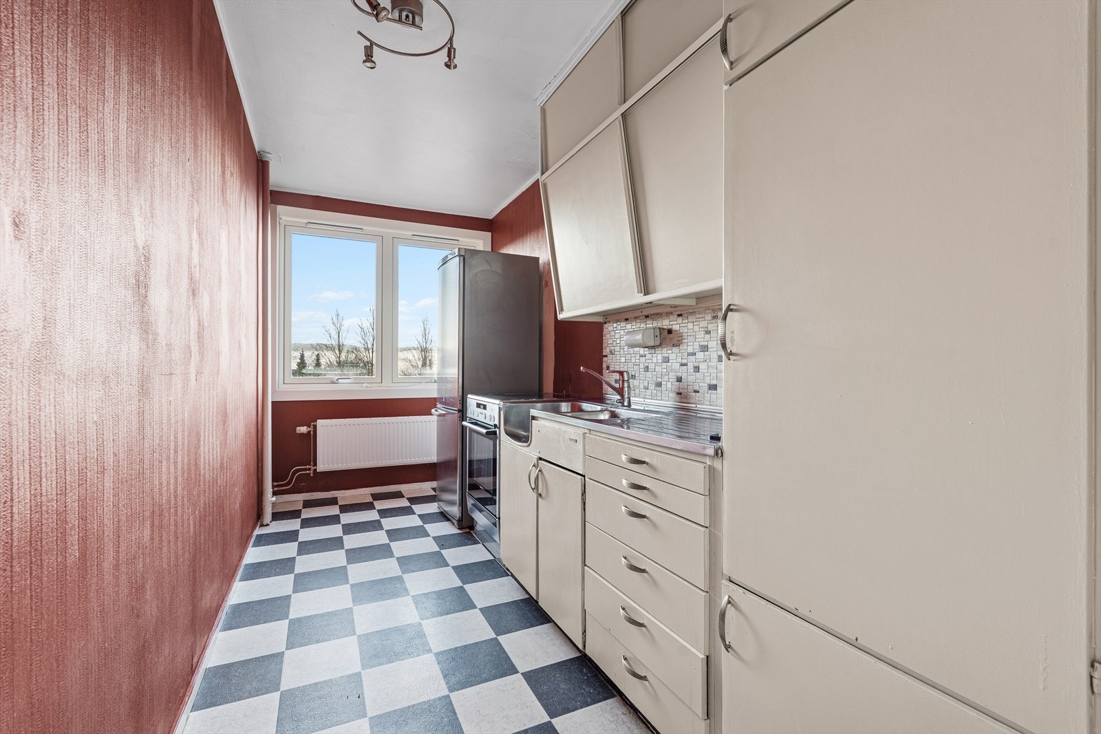 Leiligheten har separat kjøkken. Kjøkkenet har innredning med glatte fronter. Benkeplate er av stål med integrert vask. Det er fliser på vegg over kjøkkenbenken. Galleribilde