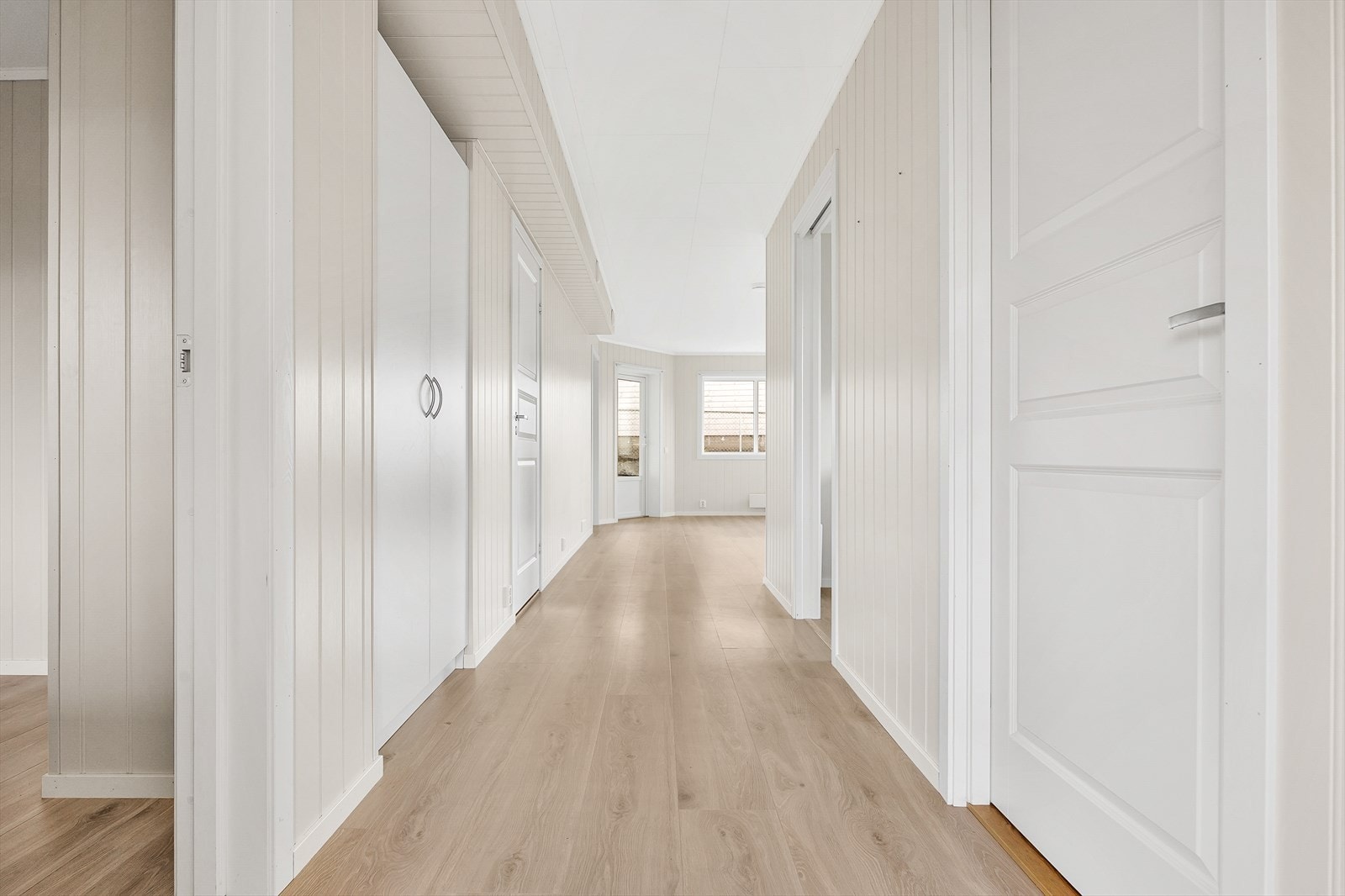 Gjennomgående laminatgulv og lyse veggflater skaper en helhetlig og åpen atmosfære. Galleribilde