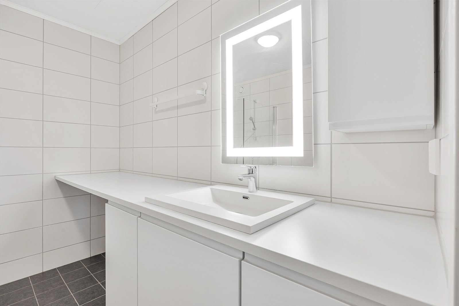 Speil med integrert belysning og god benkeplass ved servanten. Galleribilde