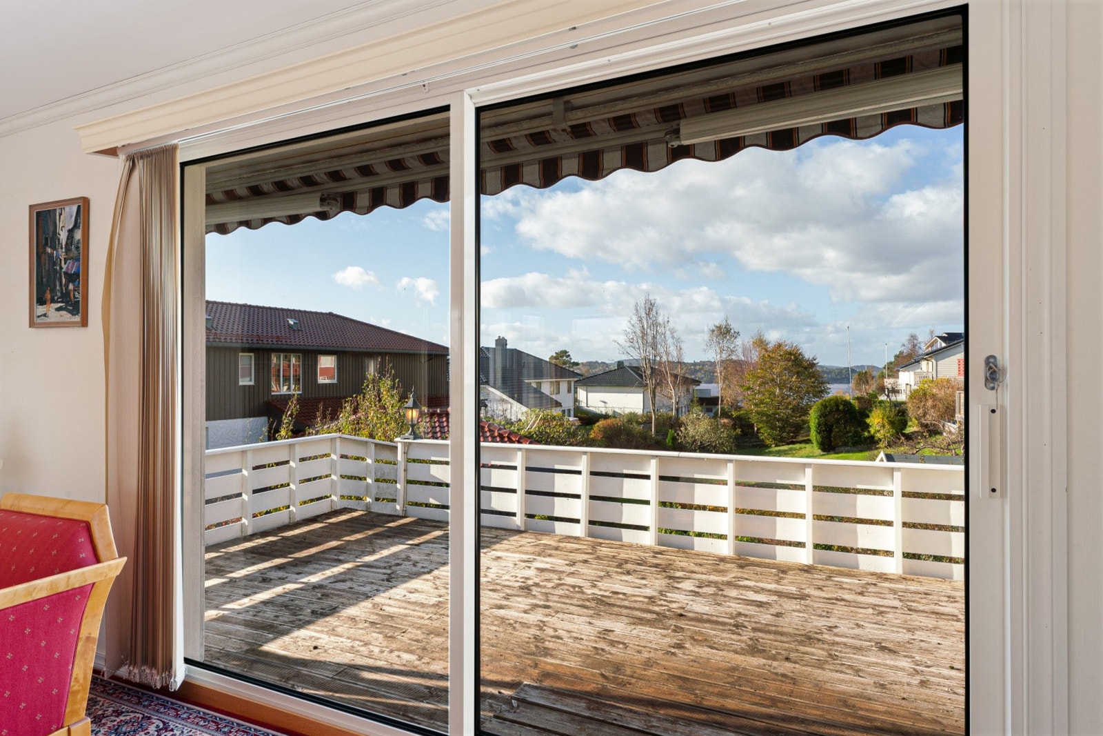 Utgang fra stue til stor terrasse med sen kveldssol sommerstid. Her er det fin utsikt mot fjorden. Galleribilde