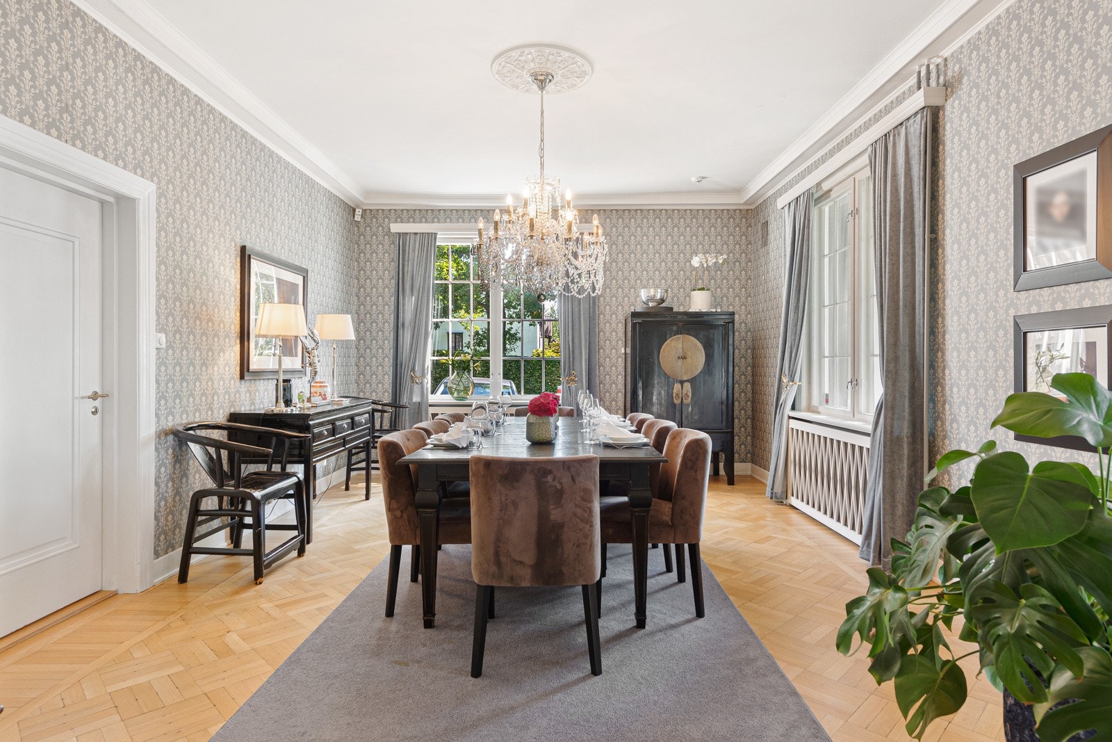 I spisestuen kommer boligens sjarm godt frem med tidsriktig tapet og parkett på gulvet, samt rosett i taket Galleribilde