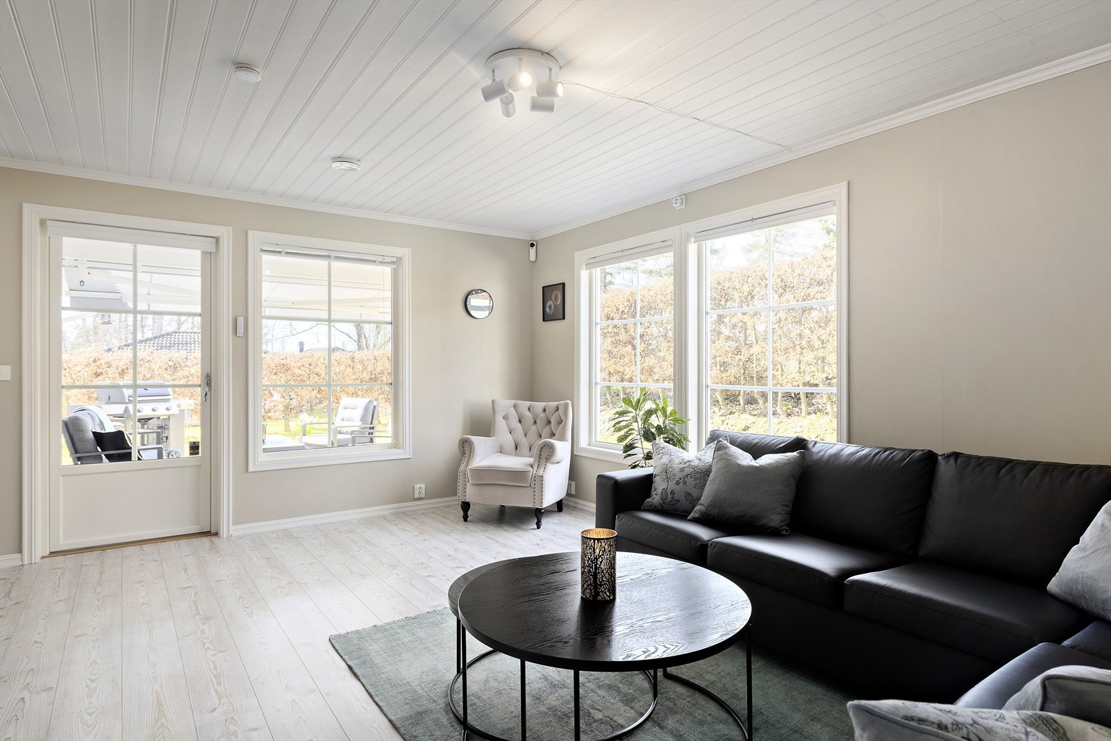 I dem romslige stuen/spisestuen er det store vinduer som slipper inn naturlig lys, og de varme, jordnære fargene skaper en innbydende atmosfære. Det er utgang direkte ut til hagen. Galleribilde