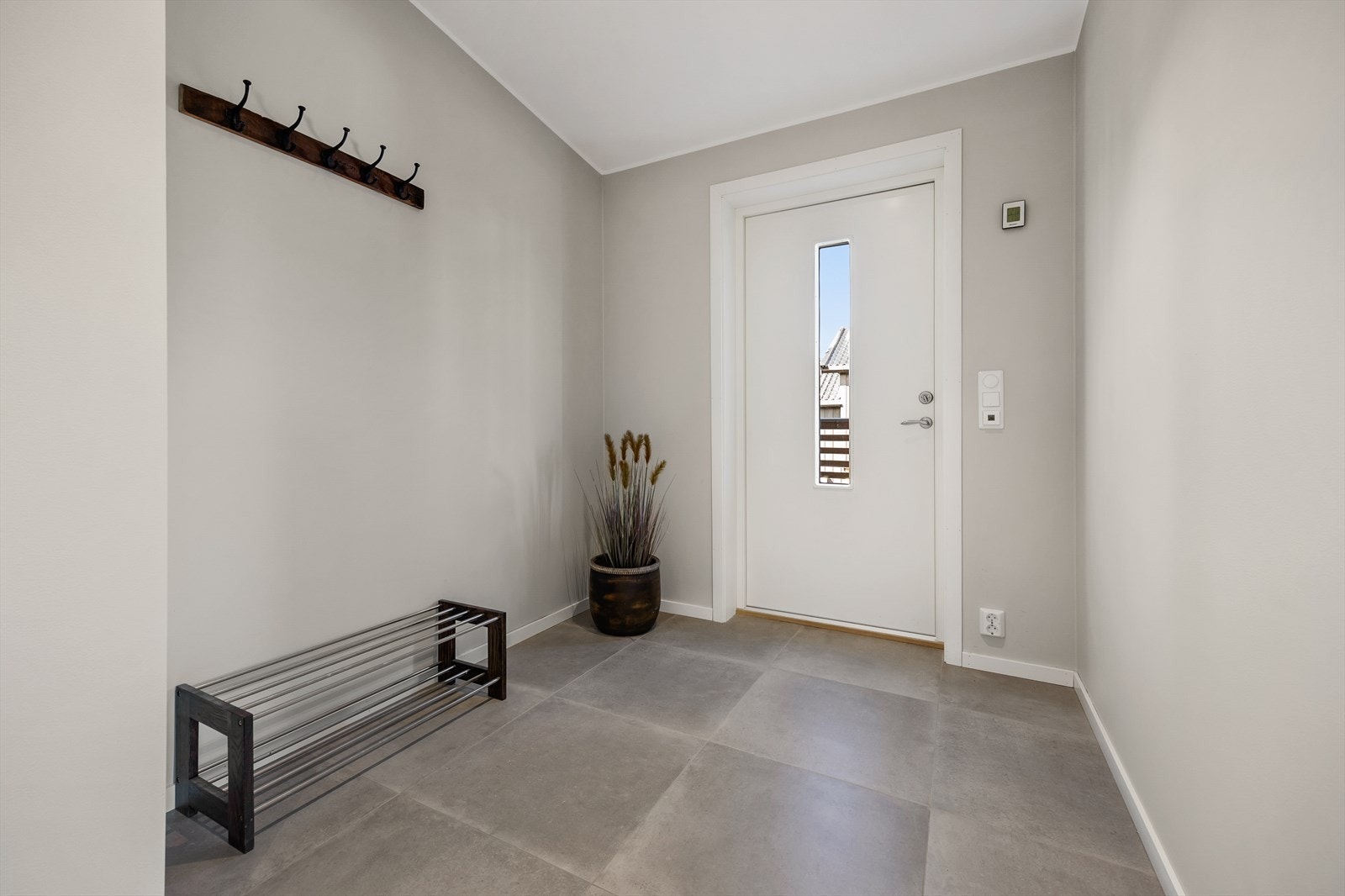Entréen har store keramiske fliser og gir et ryddig førsteinntrykk. Galleribilde