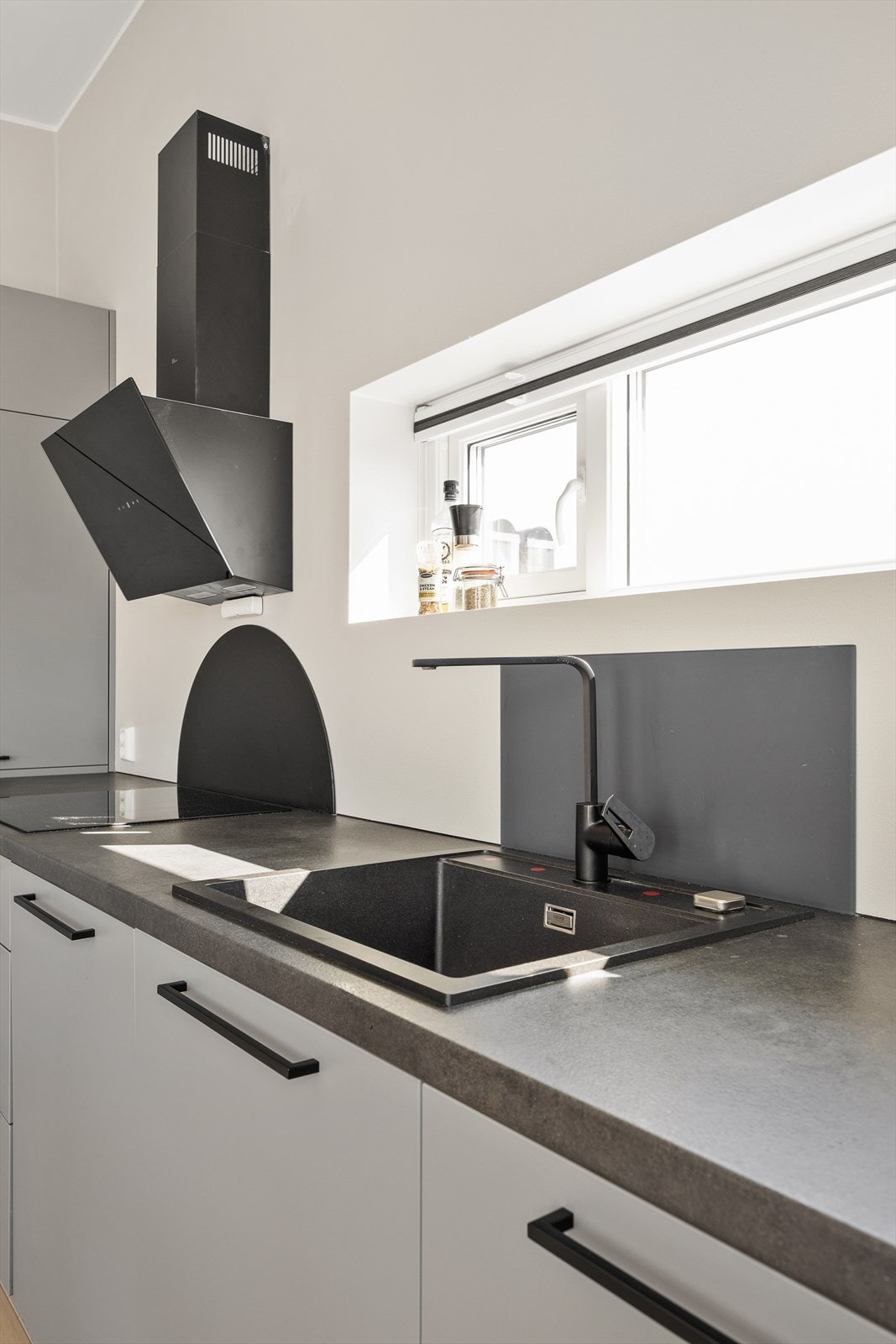 Funksjonell kjøkkenbenk med integrert koketopp og effektiv avtrekksvifte. Galleribilde