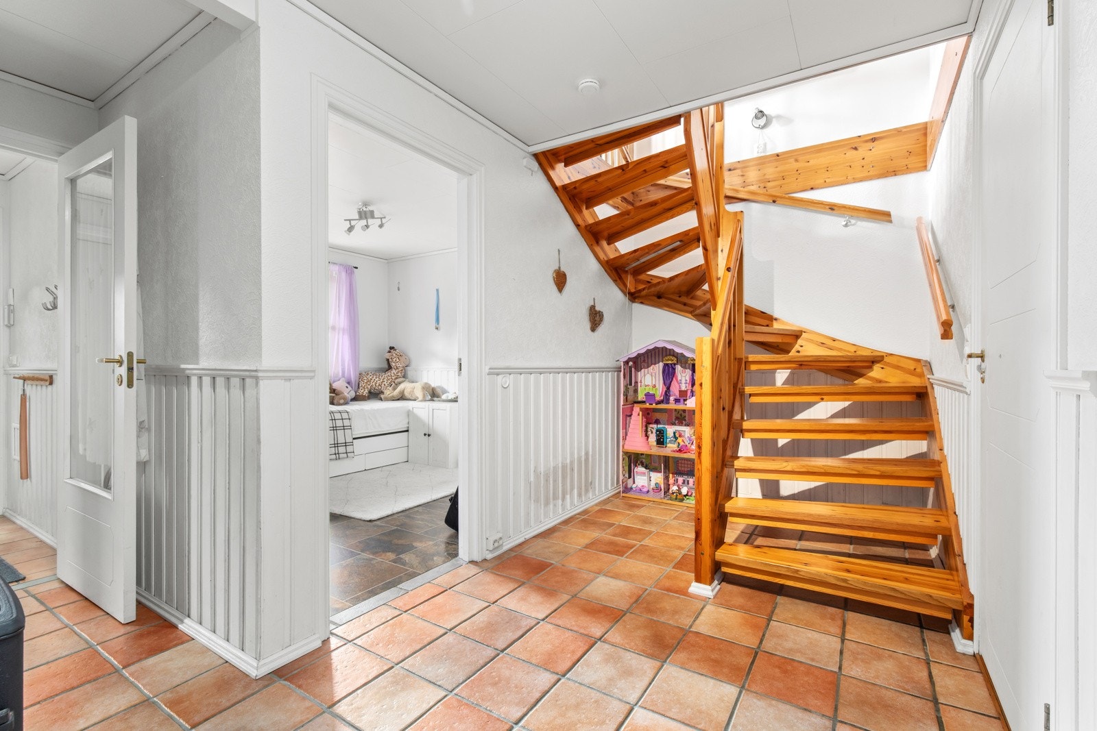 Lys og åpen gang med praktisk planløsning og tretrapp opp til boligens andre etasje. Galleribilde