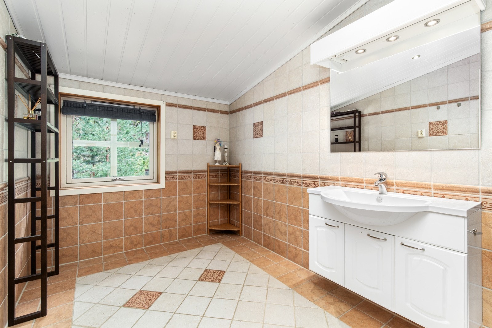 Badet er klassisk innredet med servant over servantskap med profilerte fronter. Galleribilde