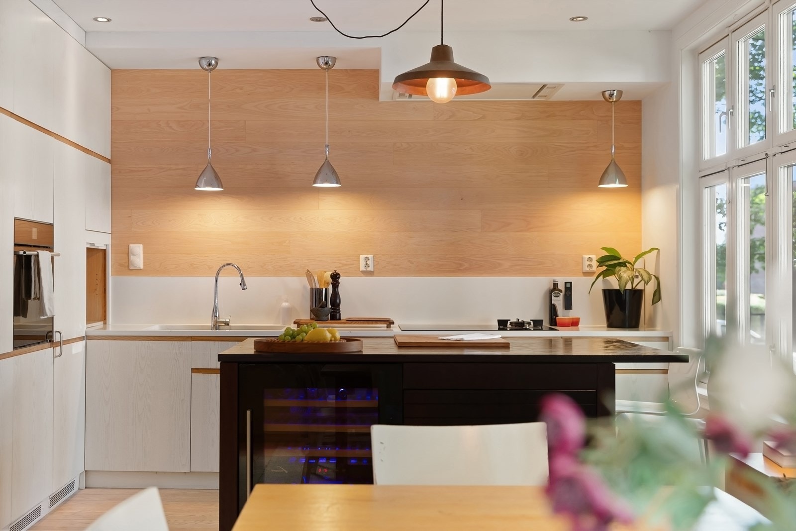 Komposittbenkeplaten og integrerte hvitevarer, som stekeovn, vinskap og oppvaskmaskin, gir et stilfullt og funksjonelt preg. Galleribilde