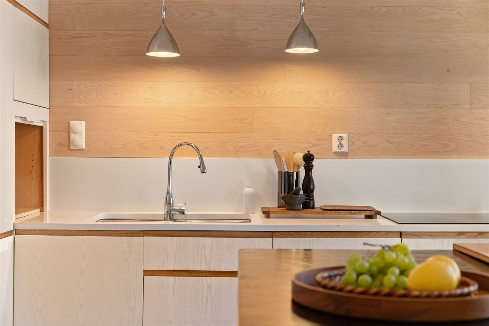 Belysning over benkeplaten og komposittstein på veggen skaper et lyst og innbydende miljø. Galleribilde