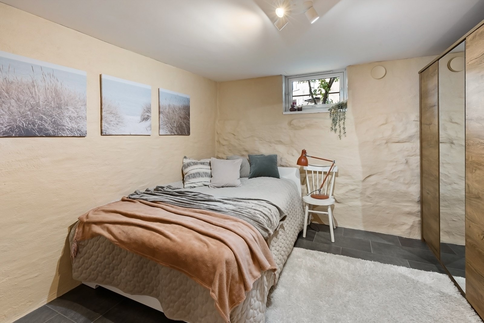 Det andre soverommet i kjelleren tilbyr et lyst og fleksibelt rom med flislagte gulv. Galleribilde