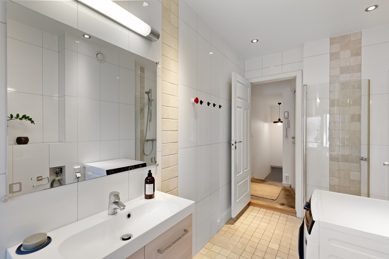 Baderomsinnredning med servant, speil og opplegg for vaskemaskin gjør hverdagen enkel. Galleribilde