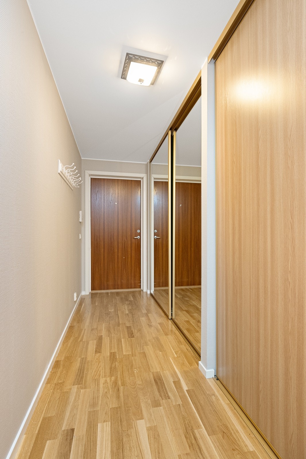 Entréen har malte, glatte dører som gir en ren finish. Galleribilde