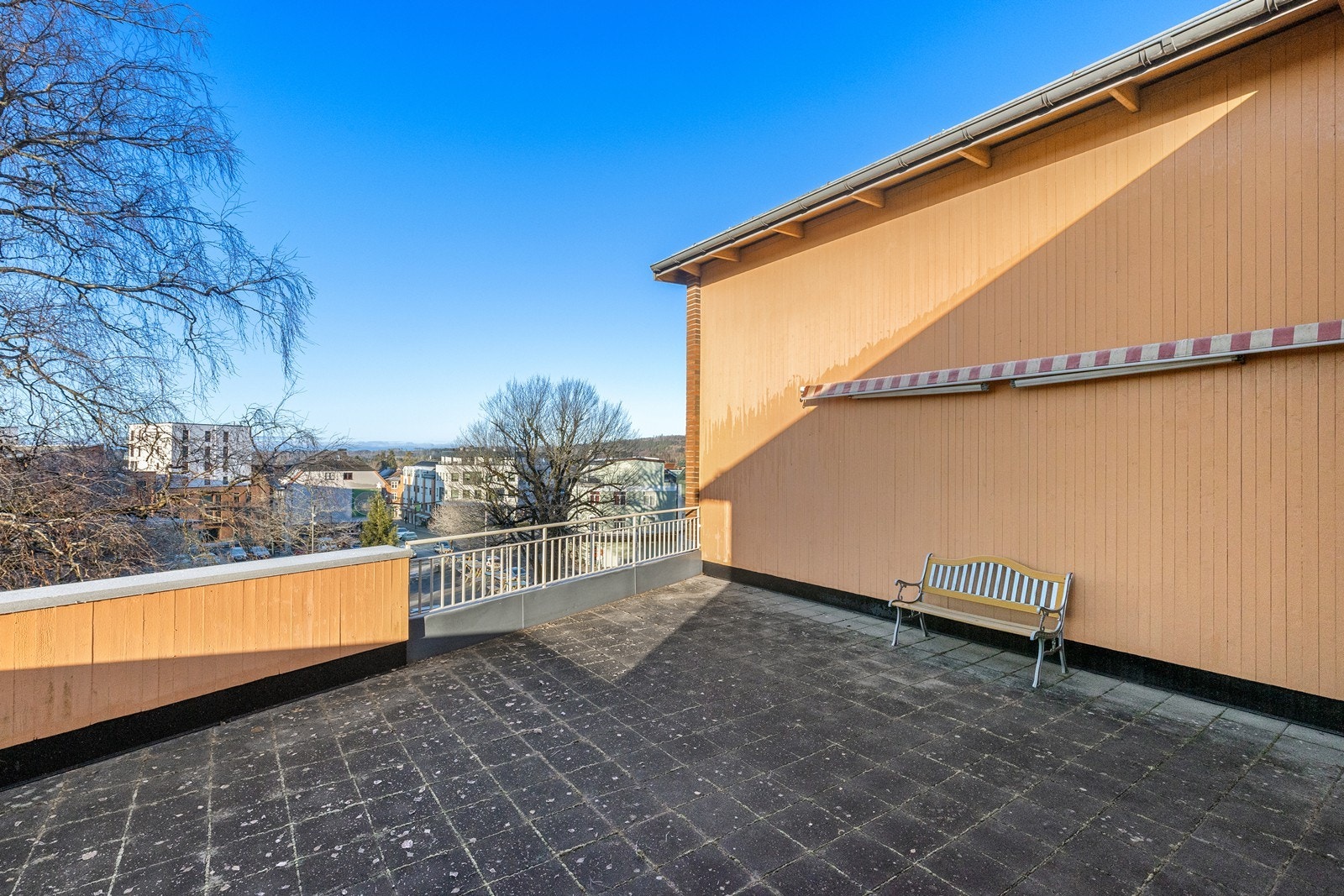 Den romslige felles takterrassen har flislagt gulv og gir utsikt over nærområdet, med plass til benker og utemøbler. Galleribilde