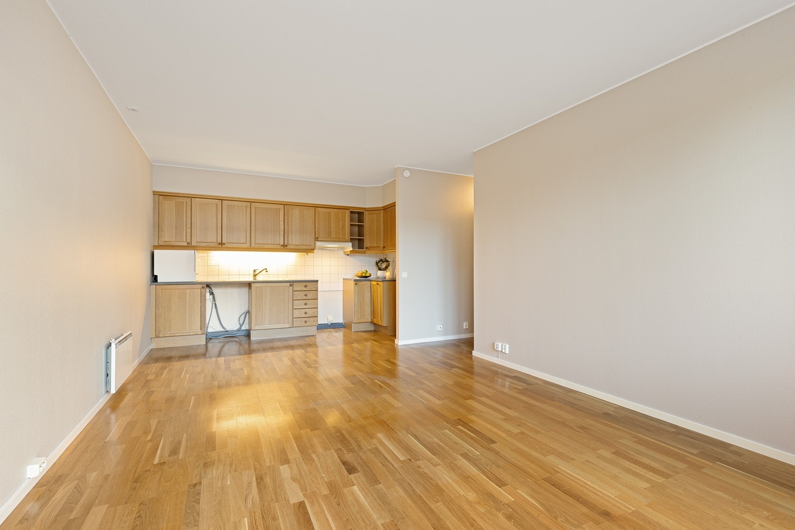 Stue med åpen løsning mot kjøkkenet gir en romslig oppholdsplass. Galleribilde