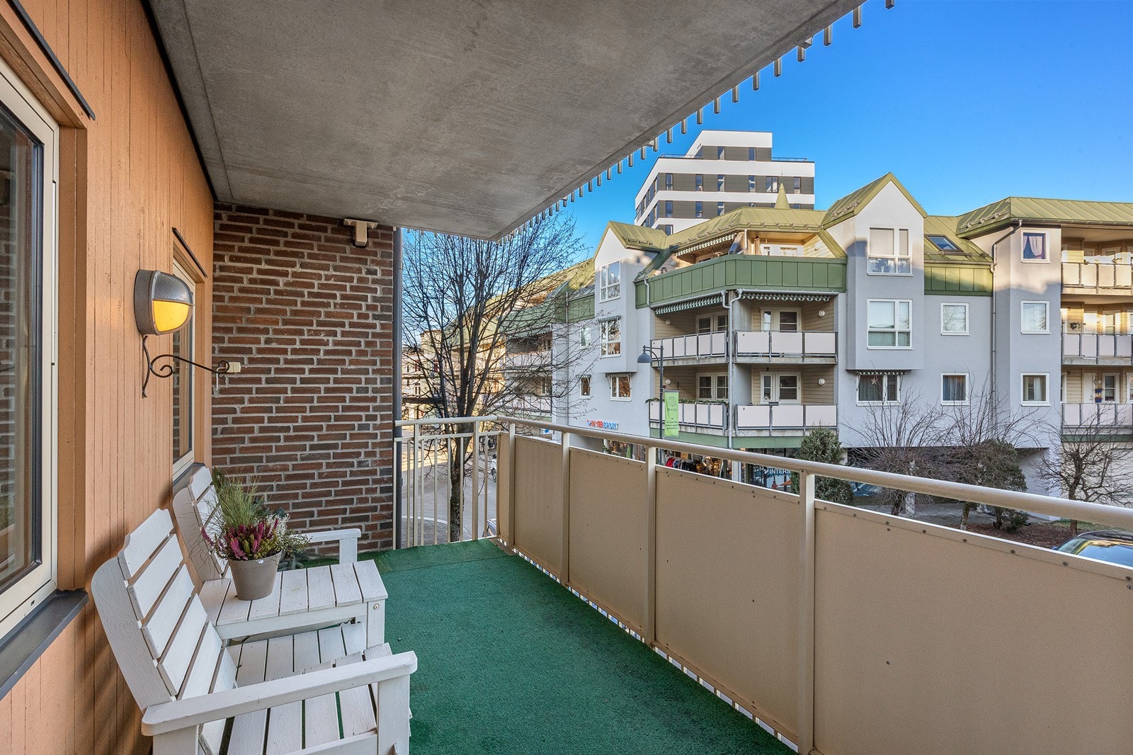 Balkongen på 10 m2 har støpt dekke belagt med teppe og rekkverk i stål, med stikkontakt og belysning på veggen. Galleribilde