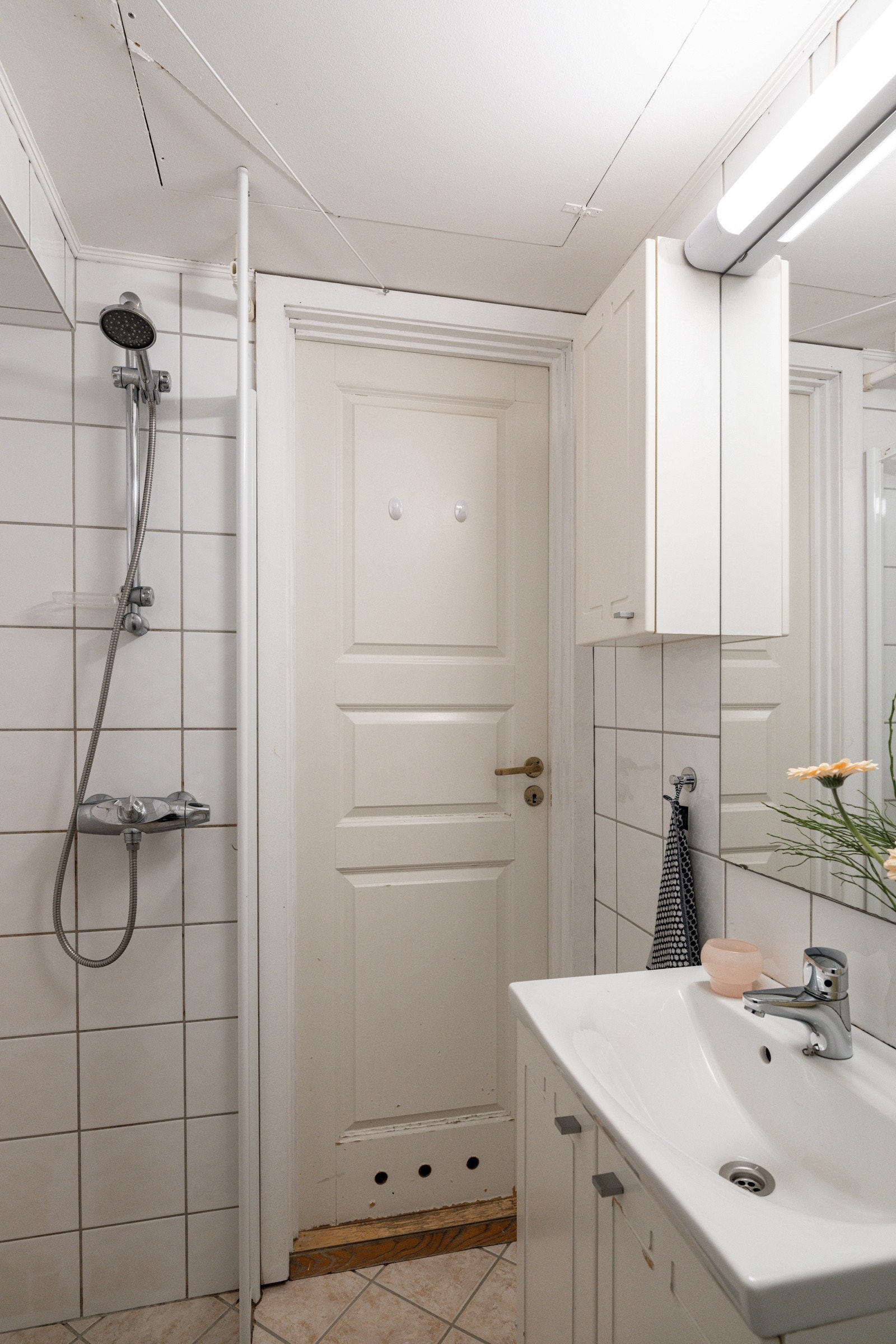 Baderommet har flislagte overflater og er utstyrt med servantskap med speil og belysning over, vegghengte skap, dusjhjørne, gulvstående toalett og stråleovn. Galleribilde