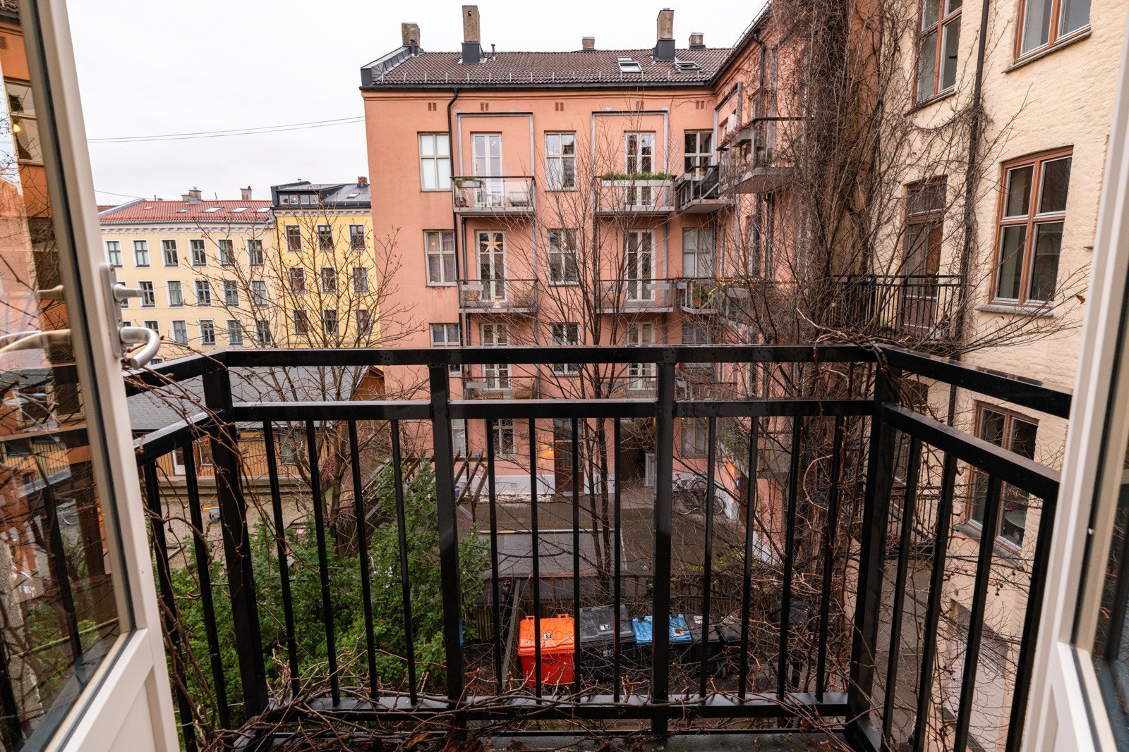 Hyggelig utsyn over bakgården som er frodig beplantet. Galleribilde