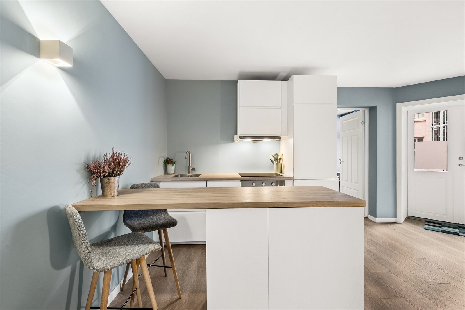 Moderne og stilren kjøkkenløsning med lyse farger og funksjonell utforming. Innredning med slette fronter og benkeplate av heltre. Galleribilde