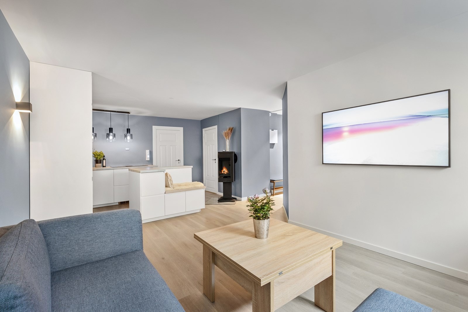 Lys og moderne stue med åpen planløsning, perfekt for sosialt samvær og avslapning. Ny peis, synlig fra kjøkken og stue. Galleribilde