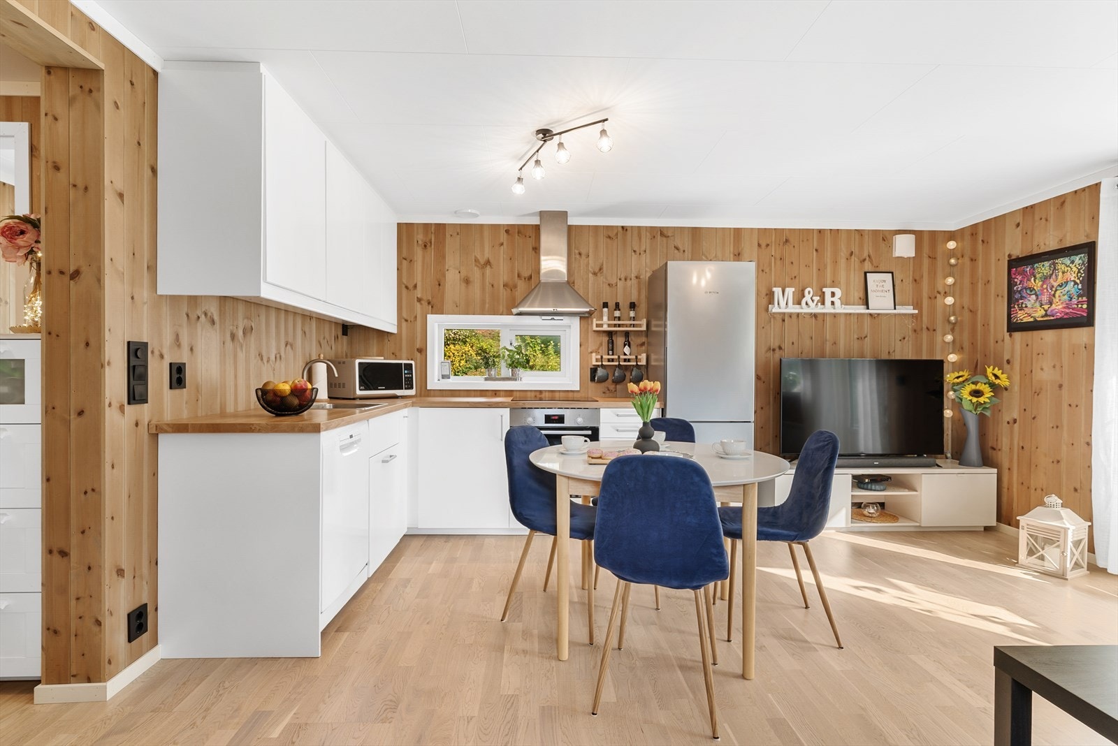 Den lyse kjøkkeninnredningen skaper en fin kontrast mot veggene. Benkeplaten er i laminat. Galleribilde