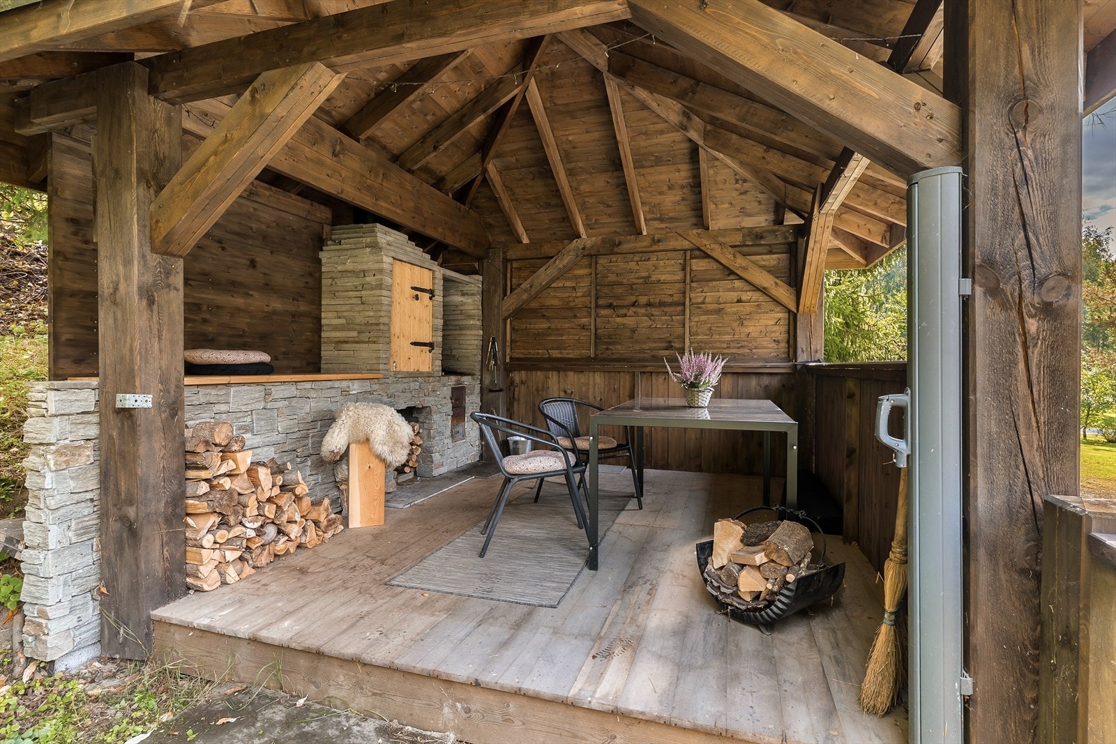 En hyggelig, frittstående paviljong er innredet som grillplass. Galleribilde