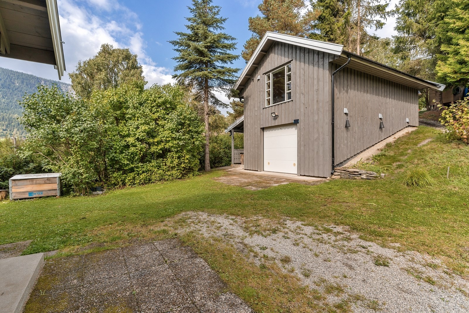 Garasjen har parkering i første etasje og et praktisk, innredet rom i etasjen over. Galleribilde