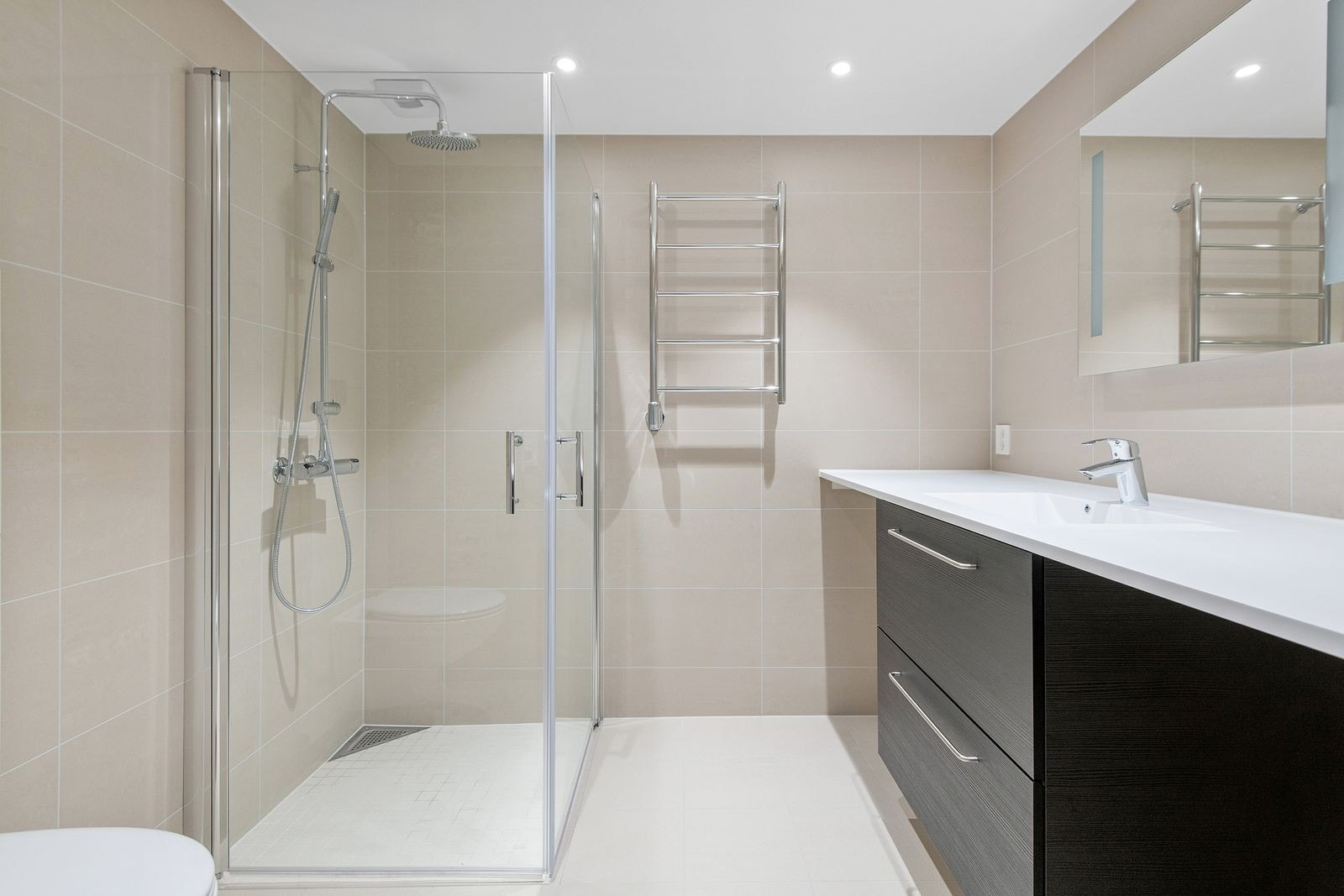 Pent flilsagt bad med varmekabler. Her er det opplegg for vaskemaskin og tørketrommel. Galleribilde