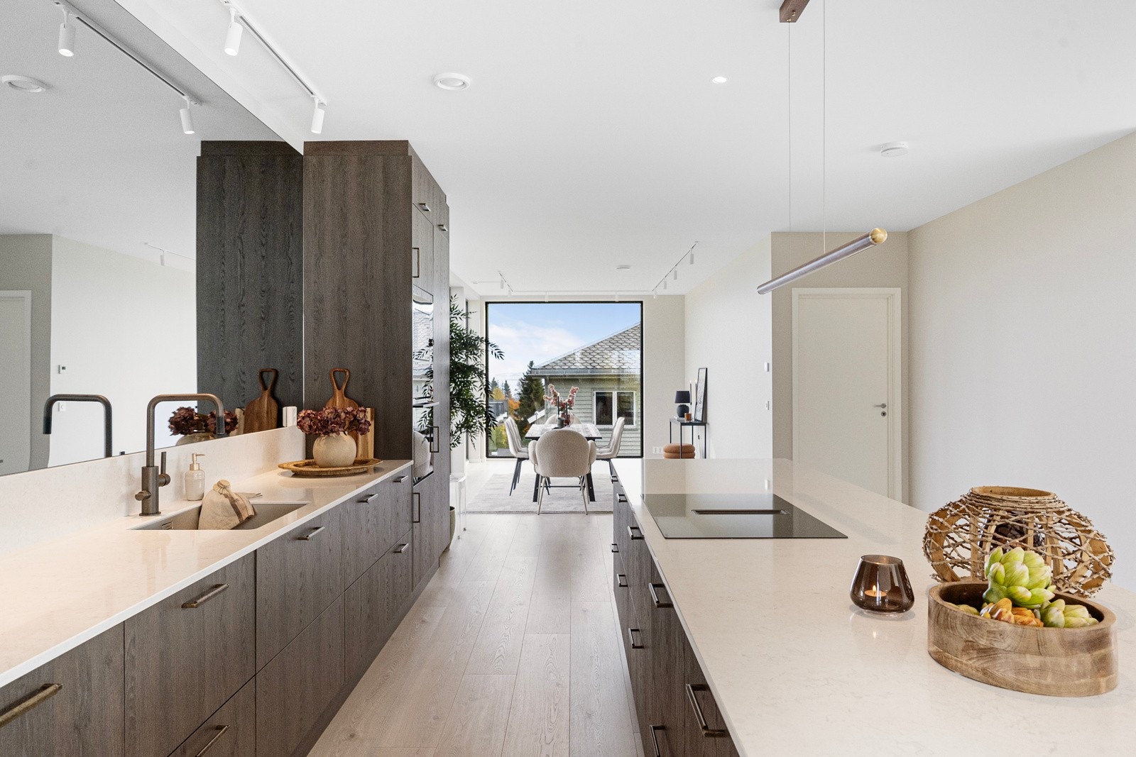 Nedfelt ventilator i koketoppen og speil på veggen over benken tilfører både stil og funksjon. Galleribilde