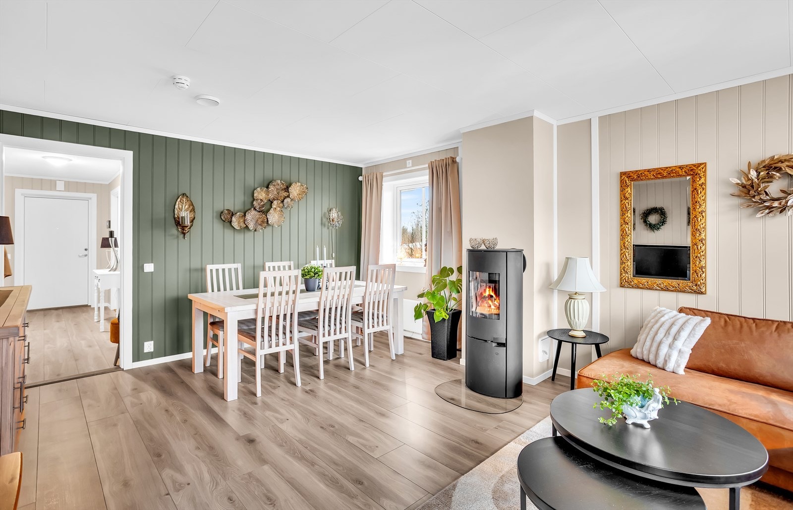 Stuen er et lyst og åpent rom med en lukket vedovn som gir god varme. Galleribilde