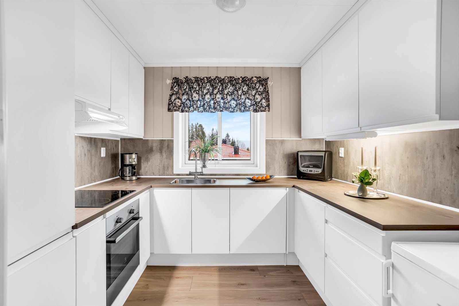 Praktisk U-formet kjøkkeninnredning fra 2019 med glatte fronter og god skapplass. Galleribilde