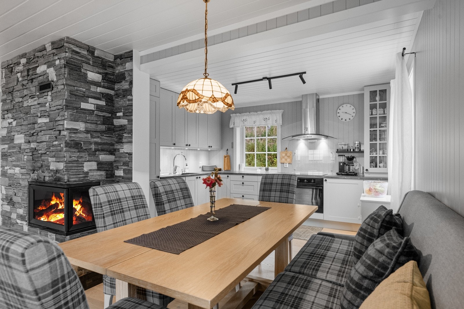 Den åpne løsningen gir en følelse av romslighet, mens peisen bidrar til en lun og innbydende atmosfære Galleribilde