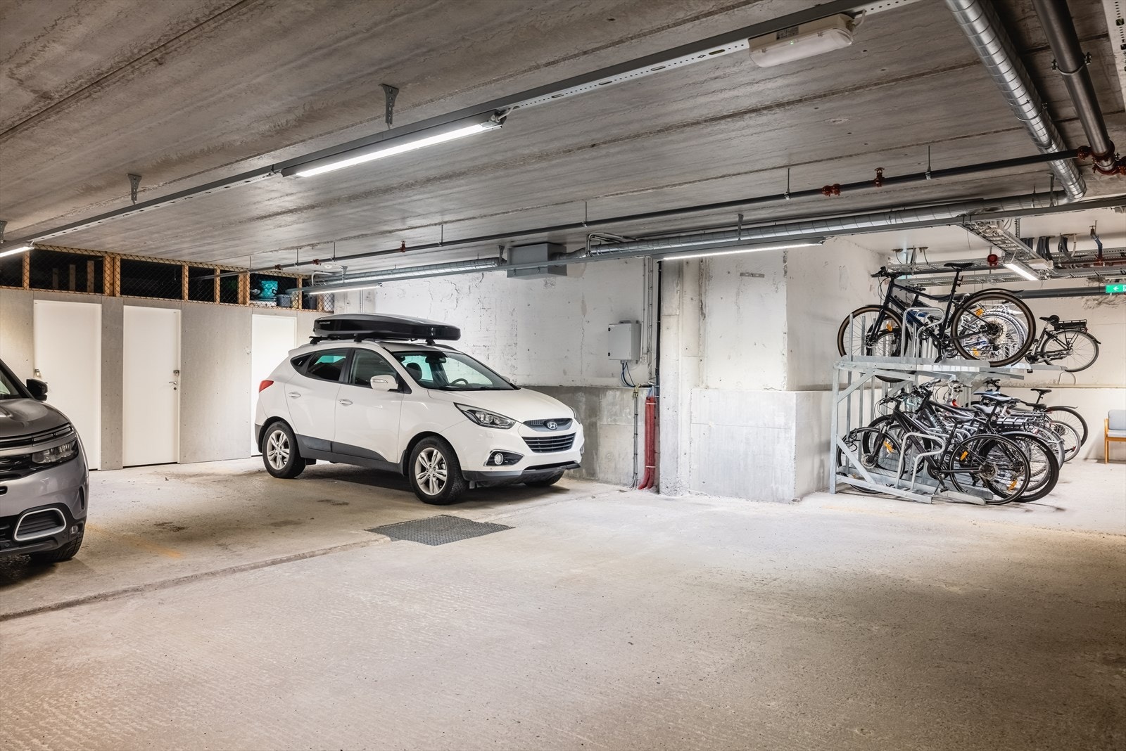 Leiligheten har bruksrett til en fast, innendørs parkeringsplass. Her kan man gå tørskodd helt til og fra leiligheten. Galleribilde