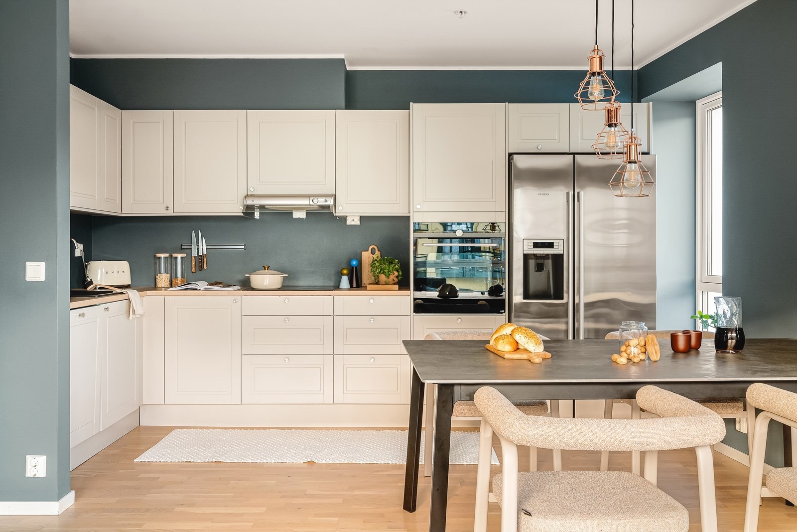 Lys og pen kjøkkeninnredning fra Norema med profilerte fronter. Galleribilde