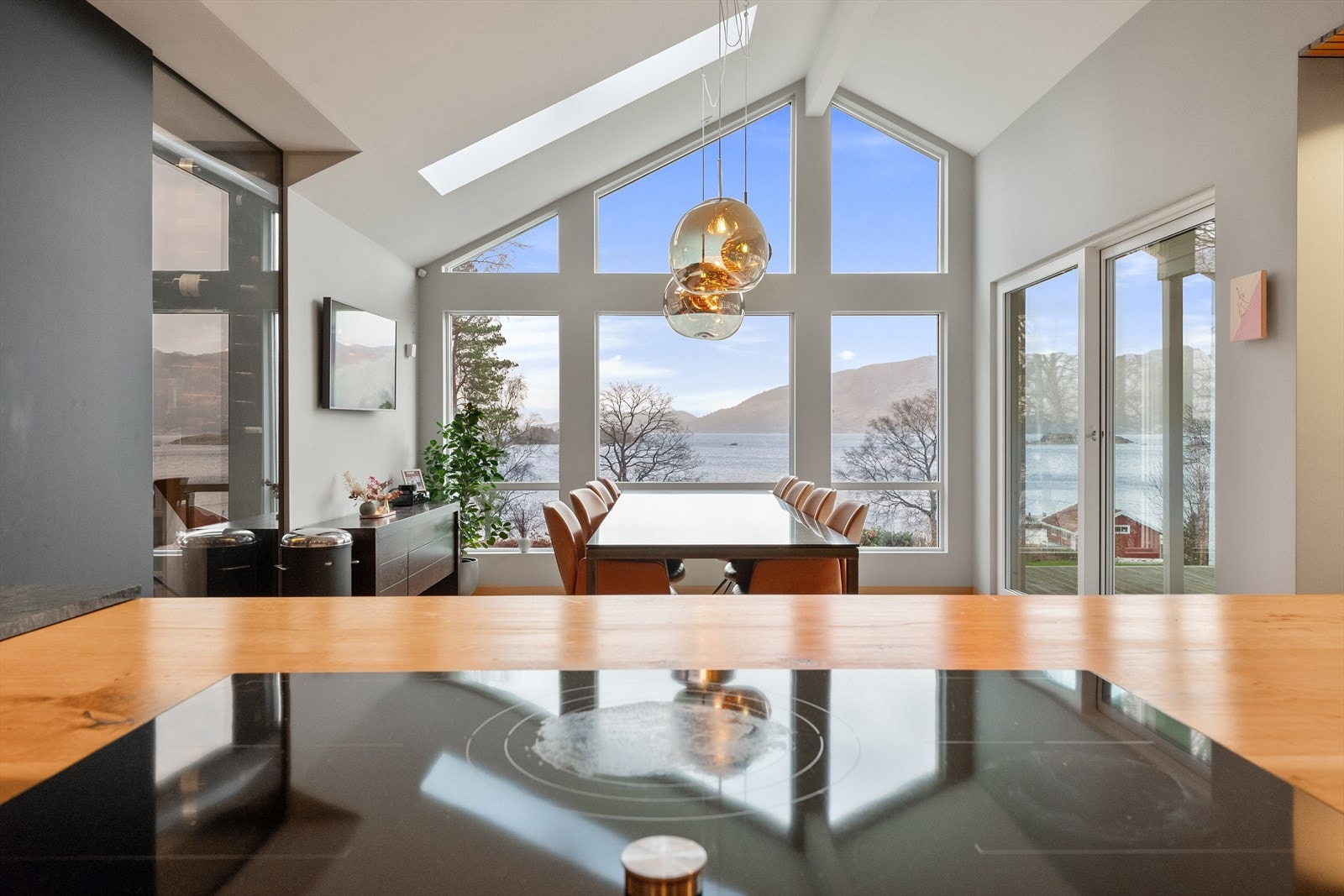 Et nydelig kjøkken/allrom med utsikt over fjord og fjell, store vinduer som slipper inn naturlig lys. Perfekt for naturopplevelser. Galleribilde