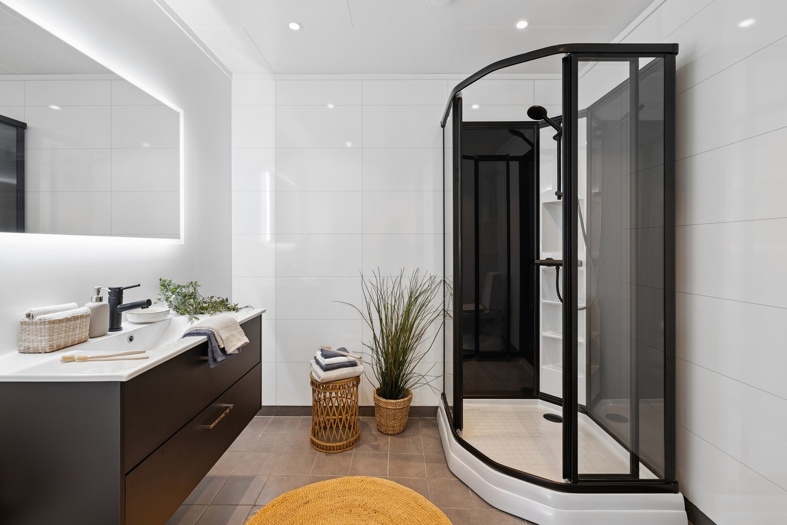 Hovedbadet er innredet med moderne baderomsmøbler og et romslig dusjkabinett. Galleribilde