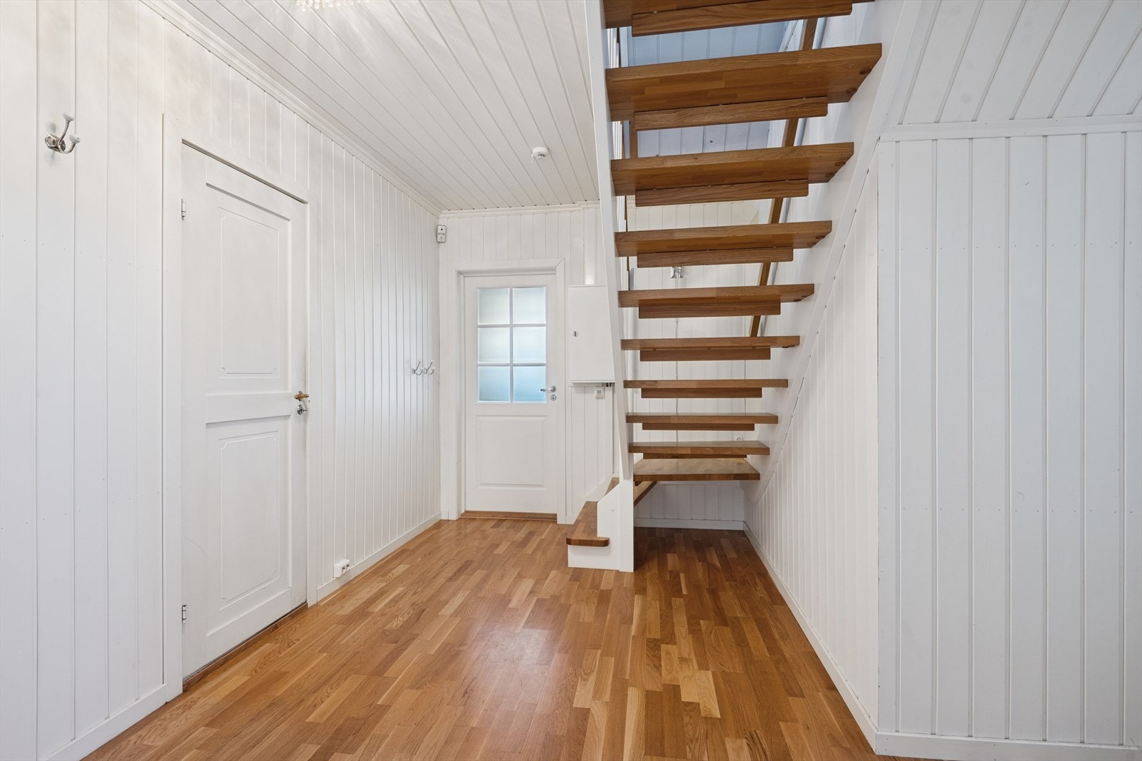 Fra hallen ved kjøkkenet fører en tretrapp opp til bygningens andre etasje. Galleribilde