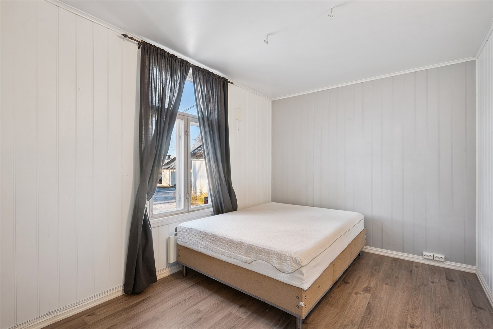 Boenheten inneholder to soverom. Her er ett av dem, med laminatgulv. Galleribilde