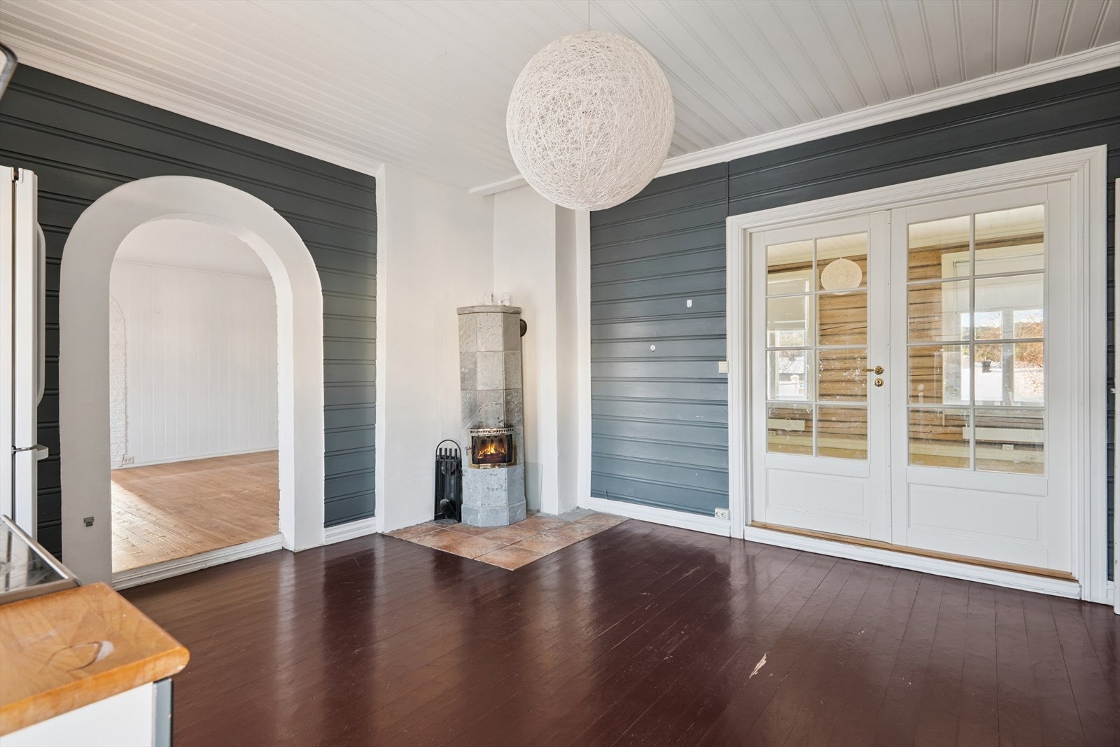 En vedovn tilknyttet mursteinspipe gir varme og atmosfære til rommet. Galleribilde