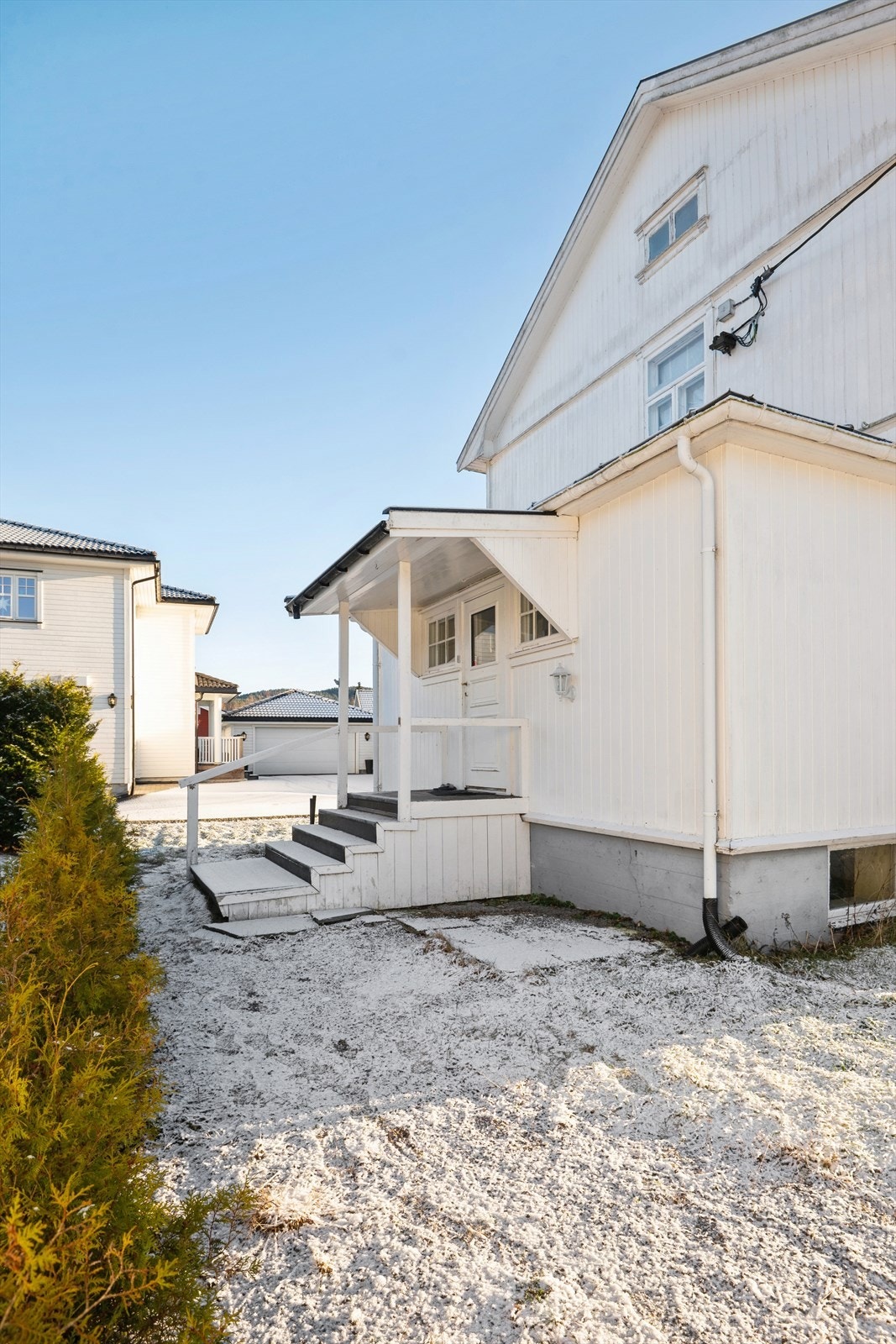 Et overbygd inngangsparti ønsker velkommen til en av boenhetene. Galleribilde