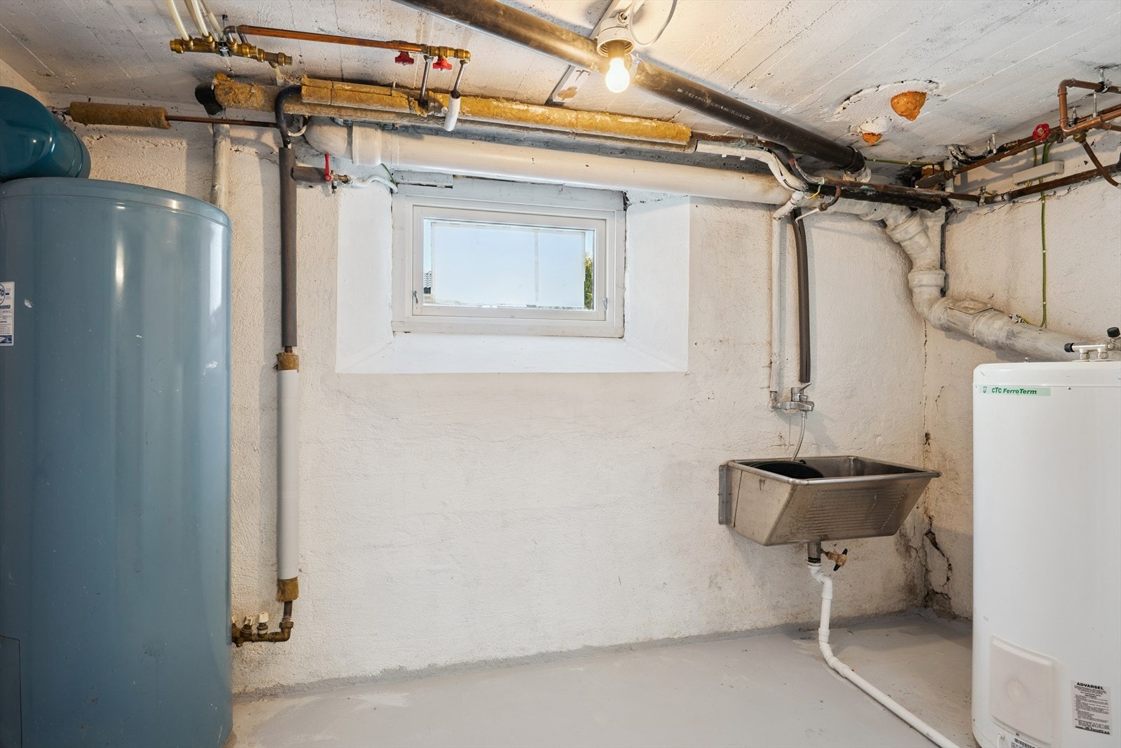 Felles vaskerom i kjelleren med skyllekar og opplegg for vaskemaskin. Galleribilde