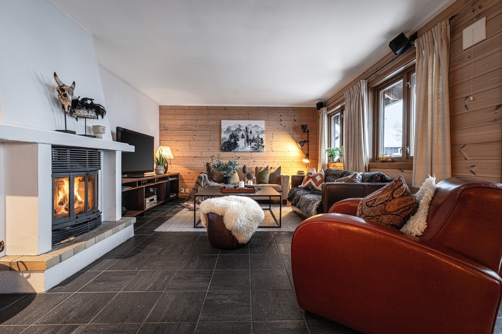 Stuen er et hyggelig samlingspunkt med peis, store vinduer og ekte fjellro. Galleribilde