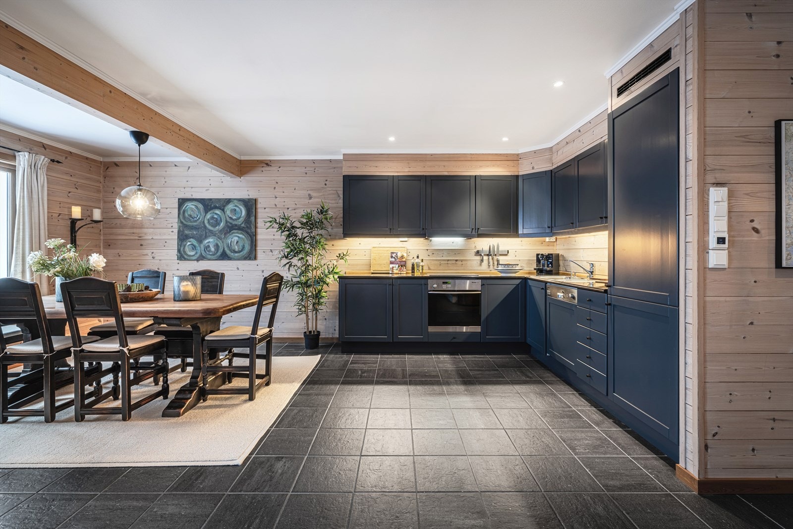 Plassbygget kjøkken med stilrene detaljer, integrerte hvitevarer samt god skap og benkeplass. Galleribilde