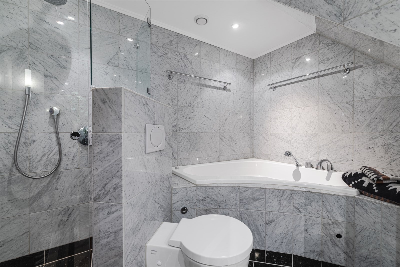 Delikat baderom med romslig hjørnebadekar, elegant dusjløsning og marmor fliser som gir en luksuriøs følelse. Galleribilde